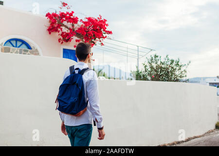 L'uomo viaggiatore a piedi nel villaggio di Akrotiri sull isola di Santorini, Grecia. Tourist ammirando il paesaggio di architettura Foto Stock