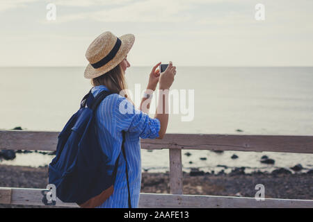 Donna traveler camminando sulla spiaggia Vlychada ad Akrotiri sull isola di Santorini, Grecia. Turistica prendendo foto di mare Foto Stock