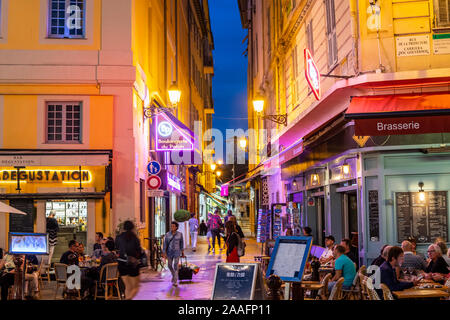 Colorato vista notturna di turisti e locali francese godendo di caffetterie nella città vecchia di Vieux Nice area di Nizza, Francia. Foto Stock