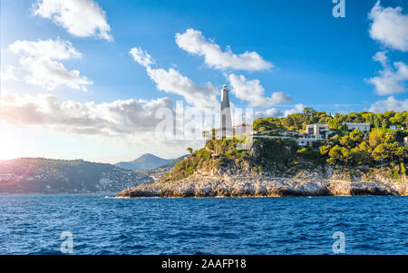 Vista dal mare mediterraneo di Saint Jean Cap Ferrat lighthouse come il sole comincia a impostare sulla Riviera francese nel Sud della Francia. Foto Stock