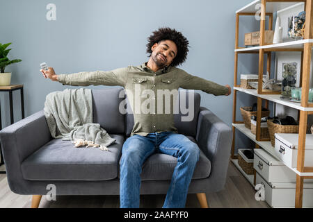 Giovane uomo rilassante sul divano di casa Foto Stock
