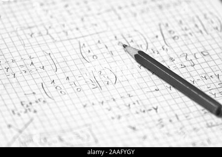 Close-up di una pagina di un notebook per studenti in cui alcuni di livello medio e di esercizi di matematica sono risolti Foto Stock