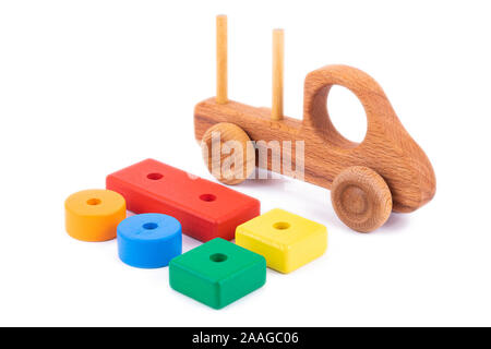 Close-up giocattolo per bambini è di legno naturale in forma di un autocarro con cassone ribaltabile con dei blocchi di legno sotto forma di multi-colore di forme geometriche su una bianca Foto Stock