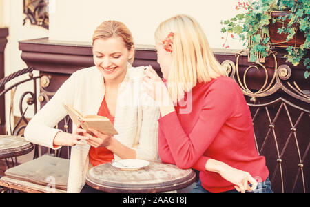 Discutendo popolare libro best-seller. Letteratura femminile. Prenota ogni ragazza dovrebbe leggere. Ragazze amici seduti cafe terrazza a bere caffè. La lettura del libro ispiratore. Miglioramento di auto e l'istruzione. Foto Stock