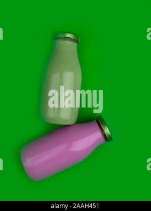 Bottiglie con una sana detox frullati su sfondo verde. Cibo sano. Foto Stock