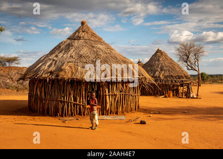 Etiopia, Sud Omo, Turmi, Hamar villaggio tribale, bambino al di fuori del tradizionale casa di legno con tetto di paglia Foto Stock