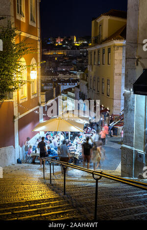Persone cenare al fresco presso Calcada do Duque, ciottolosi strada pedonale che collega Bairro Alto e Rossio a Lisbona, Portogallo, la sera. Foto Stock
