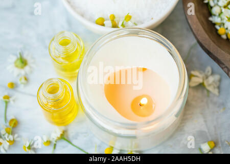 Spa still life candela con oli essenziali di bottiglie e fiori profumati e wellness e Spa candela Foto Stock