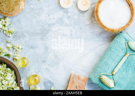 Spa ancora vita flatlay con sapone naturale, sale da bagno,l'olio bottiglie, pennello, rullo viso,fiori di gelsomino, spa e wellness sfondo Foto Stock