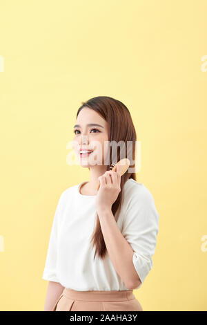 Ritratto di giovane e bella donna pettinare i capelli e sorridente Foto Stock