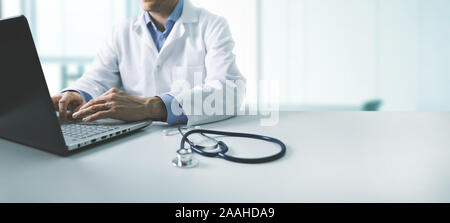 Online di consultazione medica - medico lavorando sul computer portatile in clinica ufficio. spazio copia Foto Stock