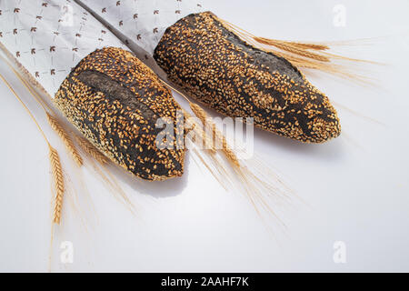 In casa del pane di pasta acida baguette nel pacchetto e grano isolato su sfondo bianco Foto Stock