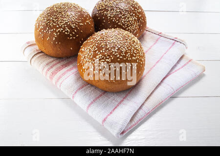 In casa del pane di pasta acida, round panini su vintage asciugatutto e sfondo di legno Foto Stock