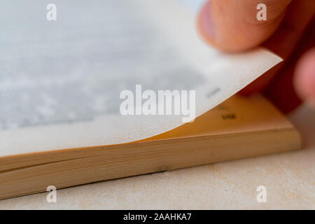 Close up macro shot di persona le dita della mano girare le pagine di un libro Foto Stock