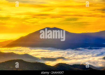 Incredibile tramonto su brumoso paesaggio. Vista panoramica della mattinata nebbiosa Sky Con Rising Sun sopra Bosco nebbioso. Monti Rodopi. Xanthi Tracia, Grecia Foto Stock