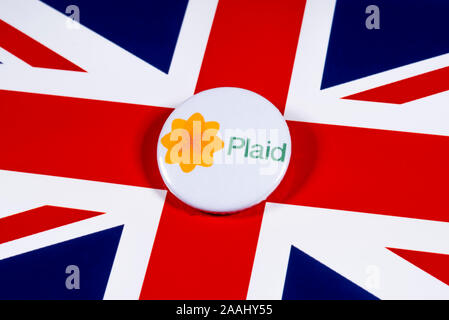 London, Regno Unito - 21 Novembre 2019: Plaid Cymru - Partito del Galles pin badge, nella foto sopra il Regno Unito bandiera. Le elezioni generali britanniche è tenuto plac Foto Stock