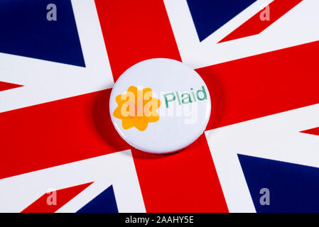 London, Regno Unito - 21 Novembre 2019: Plaid Cymru - Partito del Galles pin badge, nella foto sopra il Regno Unito bandiera. Le elezioni generali britanniche è tenuto plac Foto Stock