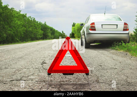 Auto con problemi e un triangolo rosso per avvertire gli altri utenti della  strada Foto stock - Alamy