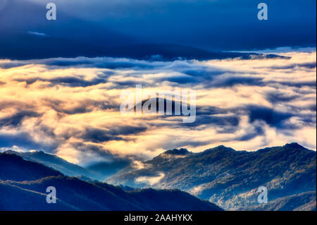 Vista panoramica delle montagne, autunno paesaggio con colline nebbiose di sunrise. Monti Rodopi. Xanthi Tracia, Grecia Foto Stock