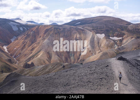 Escursionista esplorando montagne, Brennisteinsalda e Bláhnjúkur, Landmannalaugar, altopiani, Islanda Foto Stock