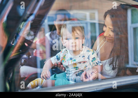 Coppia con bambini seduti all'interno dell'auto Foto Stock
