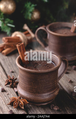 La tazza fumante di cioccolata calda sul rustico superficie in legno con albero di Natale in background Foto Stock