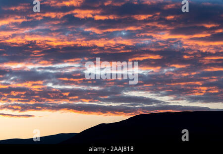 Nuvole cattura l'ultimo bit del sole serale e bagliore arancione, al di sopra del Yorkshire Dales in Wensleydale, UK. Foto Stock