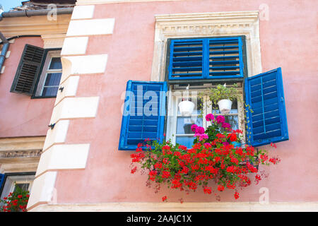 Blu di windows sulla casa di mattoni nella luce del giorno Foto Stock