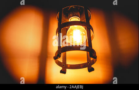 Foto di una lampada a incandescenza in luce nel supporto rustico. Foto Stock