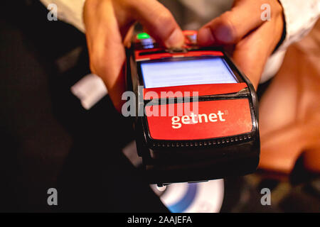 L'uomo holding società Getnet di carte di credito e di debito macchina. Foto Stock