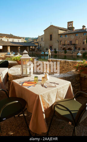 Il ristorante esterno tavoli presso le antiche terme di Bagno borgo di Bagno Vignoni in Val d'Orcia in Toscana Italia - Tuscany Ristorante Foto Stock