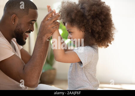 Felice biracial giovani papà giocare con la piccola figlia Foto Stock