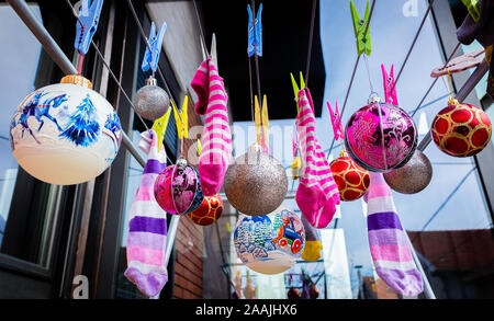 Le Palle di Natale ornamenti e calzini bagnati appesi su capi di abbigliamento di clip su stendibiancheria. Natale con lavori domestici. Foto Stock