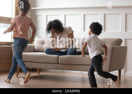 Madre africana sedersi sul lettino non sono in grado di gestire con bambini chiassosi Madre africana sedersi sul lettino non sono in grado di gestire con bambini chiassosi