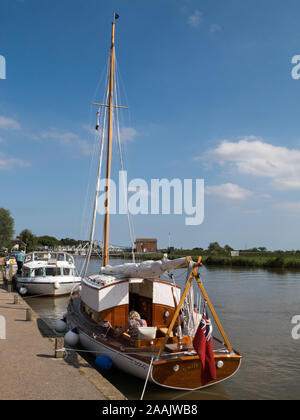 Barca a vela e River Cruiser ormeggiati sul fiume Yare, parte del Norfolk Broads National Park, presso il villaggio di Reedham, Norfolk, Inghilterra, Regno Unito Foto Stock