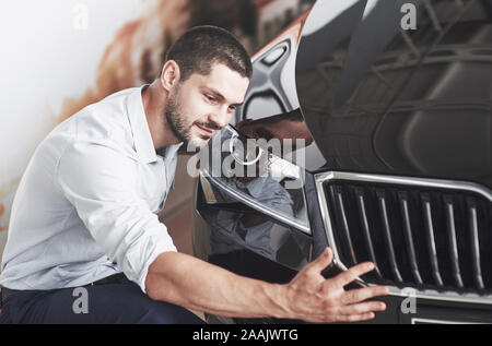 Ritratto di un felice uomo sorridente che sceglie una nuova vettura in cabina. Foto Stock