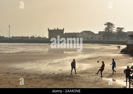 La spiaggia di fronte alla città murata di Essaouira, un sito Patrimonio Mondiale dell'Unesco. Il Marocco Foto Stock