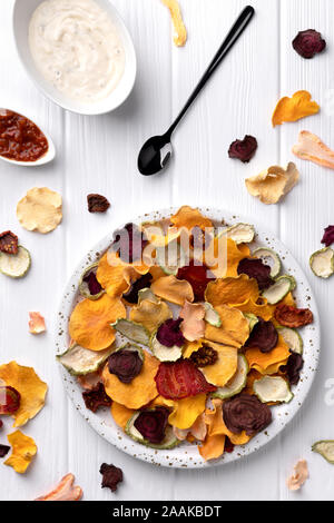 Croccante croccante di verdure biologiche chip con forno a legna di zucca, barbabietole, pomodoro, carota chips snack con salsa Foto Stock