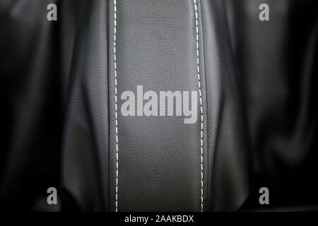 Il lusso moderno auto interni in pelle. Una parte della pelle sedile auto dettagli con cuciture di colore bianco. Interno del veicolo di prestigio. Traforata sedili in pelle. Perfora Foto Stock