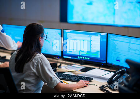 Femmina di guardie di sicurezza che lavorano in camera di sorveglianza, monitoraggio CCTV e discutere. Foto Stock