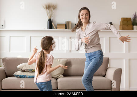 Felice giovane mamma divertiti ballando con preschooler figlia Foto Stock