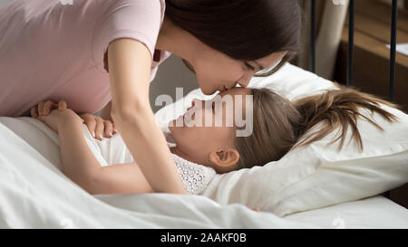 Amare la mamma kiss piccola figlia che desiderano la sua buona notte Foto Stock