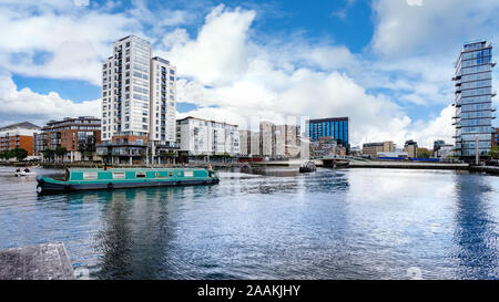 Paesaggio di Dublin Docklands e il fiume Liffey con edifici moderni e barcone sul fiume. Repubblica di Irlanda Foto Stock