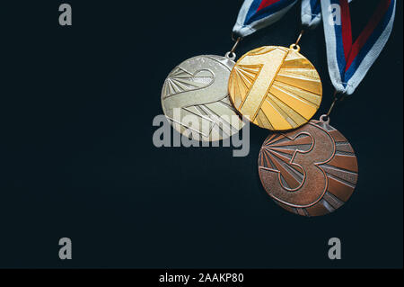 Oro, d'Argento e Medaglia di Bronzo, sport foto trofeo, sfondo nero Foto Stock