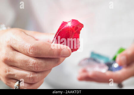 Femmina guaritore di cristallo rosso di contenimento andara crystal. Medicina alternativa concetto. Foto Stock