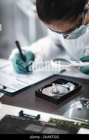 Digital forensic science. Polizia analista forense esame unità disco rigido del computer. Foto Stock