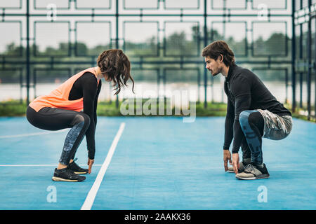 Giovane donna sportivo esercitando all aperto con personal trainer. Foto Stock
