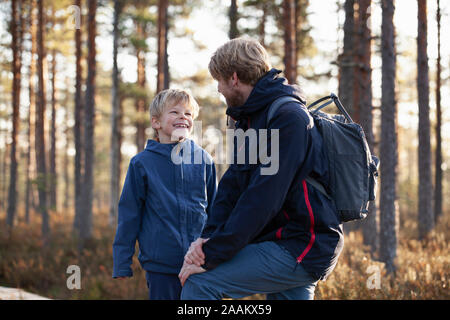 Padre e figlio parlano in foresta, Finlandia Foto Stock