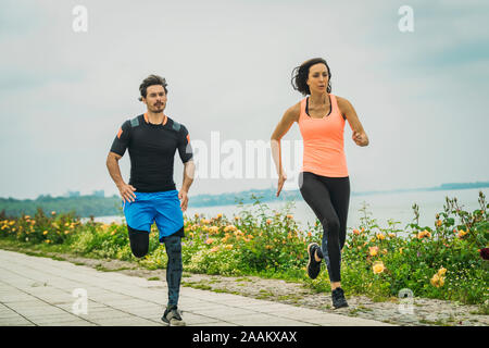 Esercizio dal fiume con personal trainer. Foto Stock