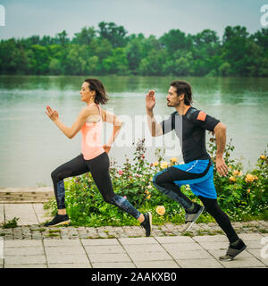 Esercizio dal fiume con personal trainer. Foto Stock